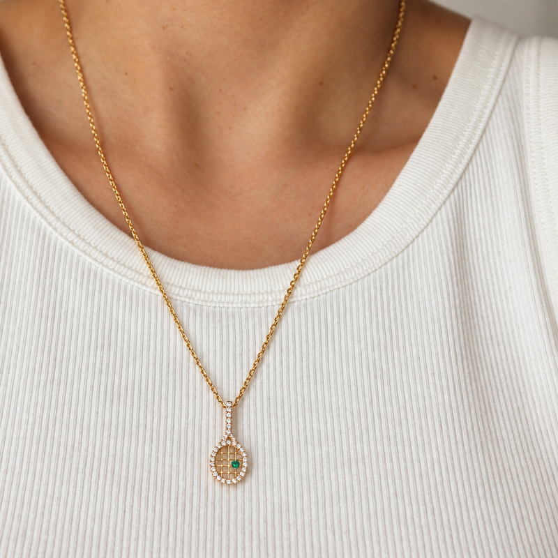 EMBLUME Ace Pendant in yellow gold, on a neck of a person.