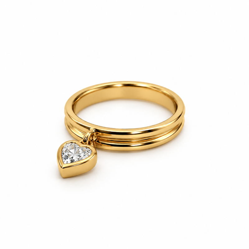 Yellow gold ring with a bezel-set heart-shaped diamond charm, photographed from an angled side view.