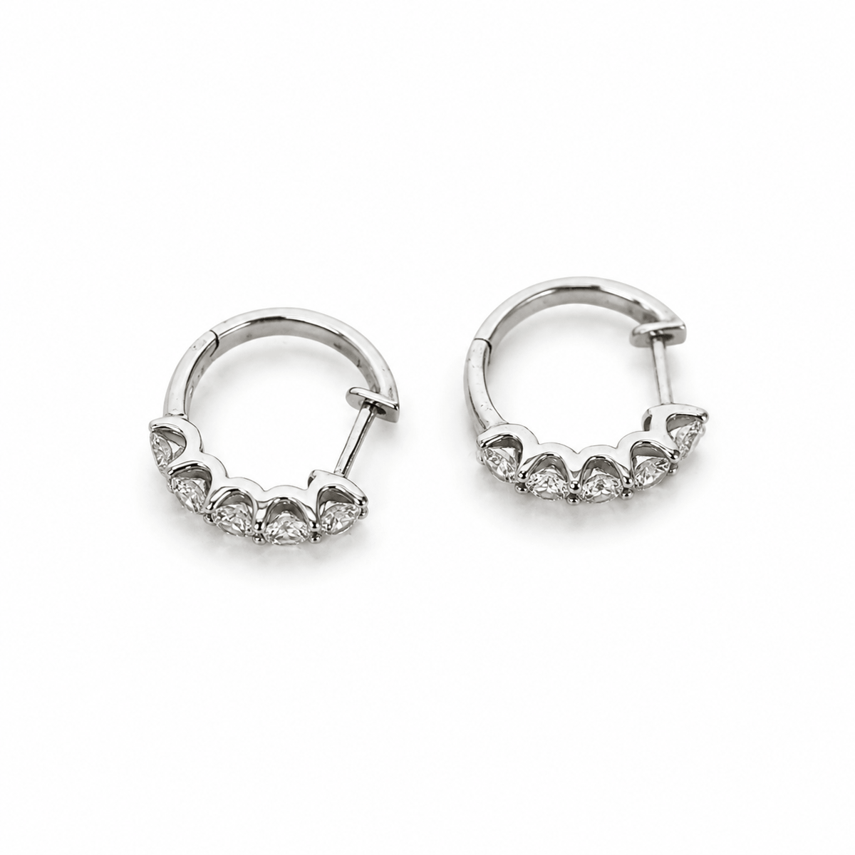 Side view of white gold diamond huggie earrings showing hinged closures by EMBLUME